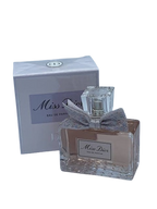 Hub Wavy Miss Dior 3.4 oz perfume bottle for women, elegant glass design with floral accents, on a neutral background.